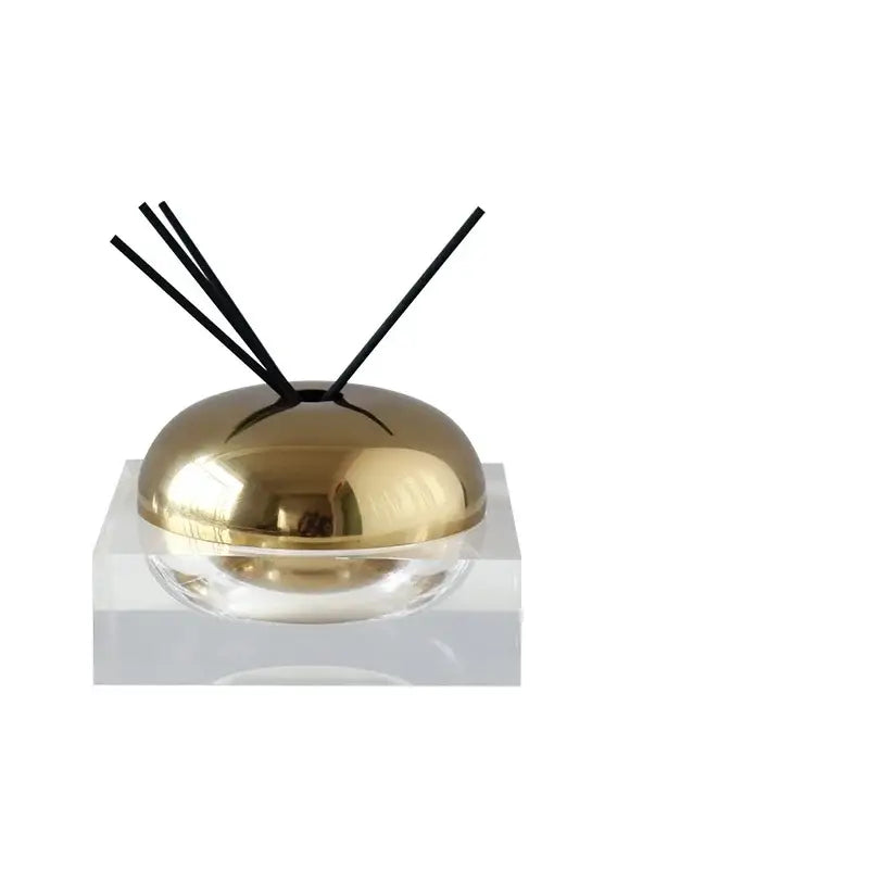 Modern gold and silver golden geometry aromatherapy diffuser with gold dome and black reeds on clear glass base for living room decor