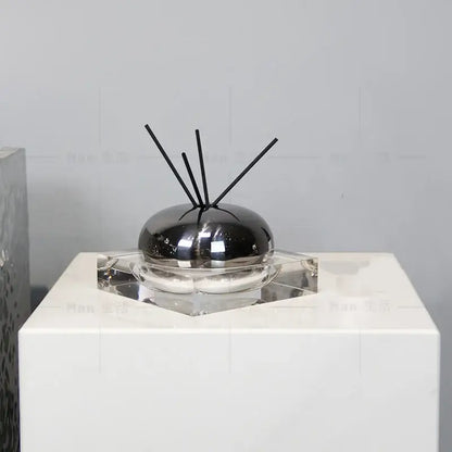 Shiny black spherical aromatherapy diffuser with clear glass base and black reeds for decorbites golden geometry living room