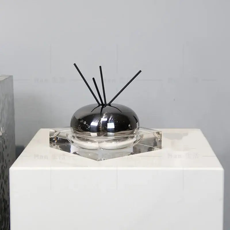 Shiny black spherical aromatherapy diffuser with clear glass base and black reeds for decorbites golden geometry living room