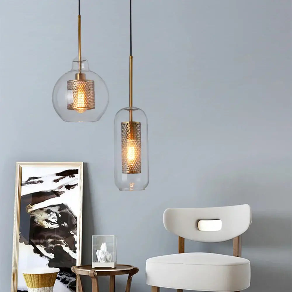 Two modern gold and silver honeycomb glass pendant lights with clear shades hanging as kitchen pendant lights