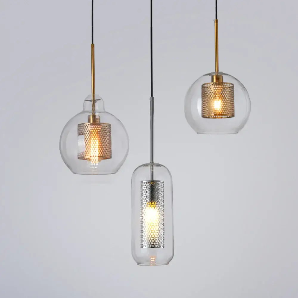 Three modern pendant lights with clear glass shades and gold and silver honeycomb metal inserts for kitchen use
