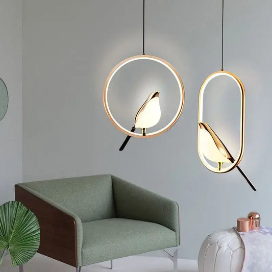 Two modern pendant lights with golden bird silhouettes and led bulbs in metallic finish for dining room use