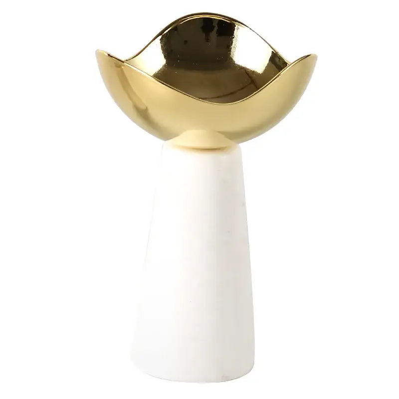 A sleek gold-toned ceramic dessert bowl with a wavy rim on a white marble pedestal for decorbites golden tray