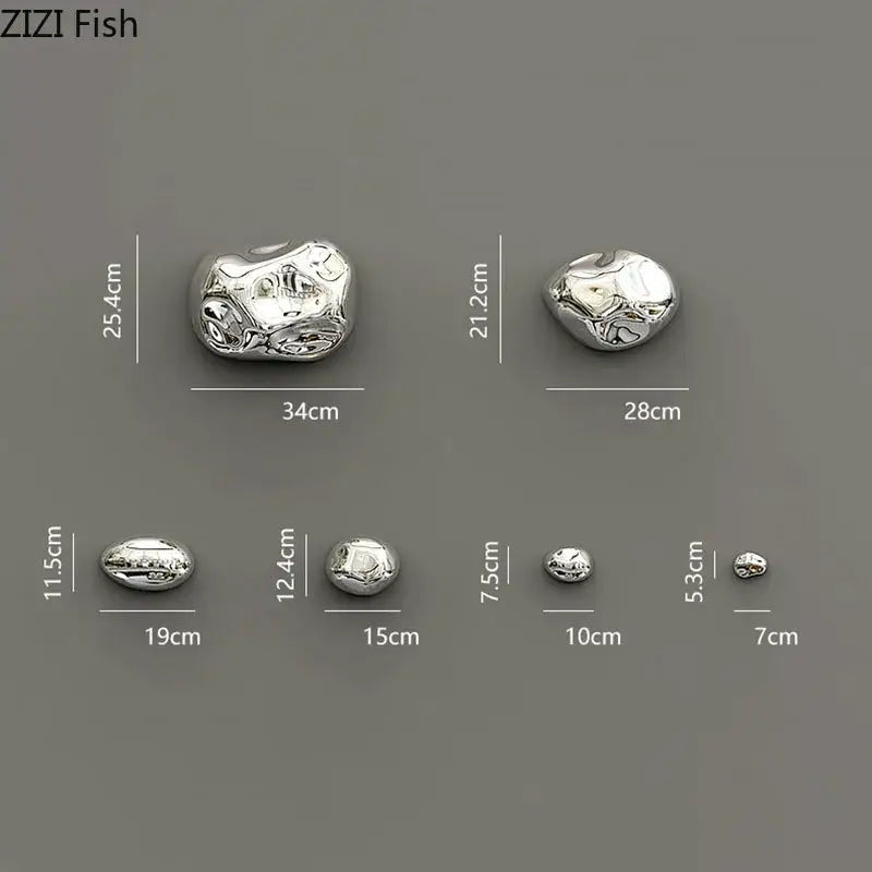 Modern silver metallic rock wall hanging ornaments with polished reflective surface and organic stone-like contours