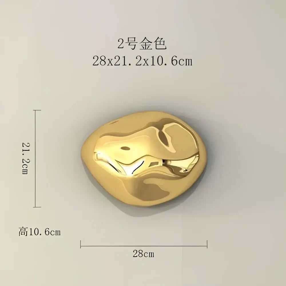 A smooth polished gold metallic wall hanging ornament with an organic irregular surface for living room decor