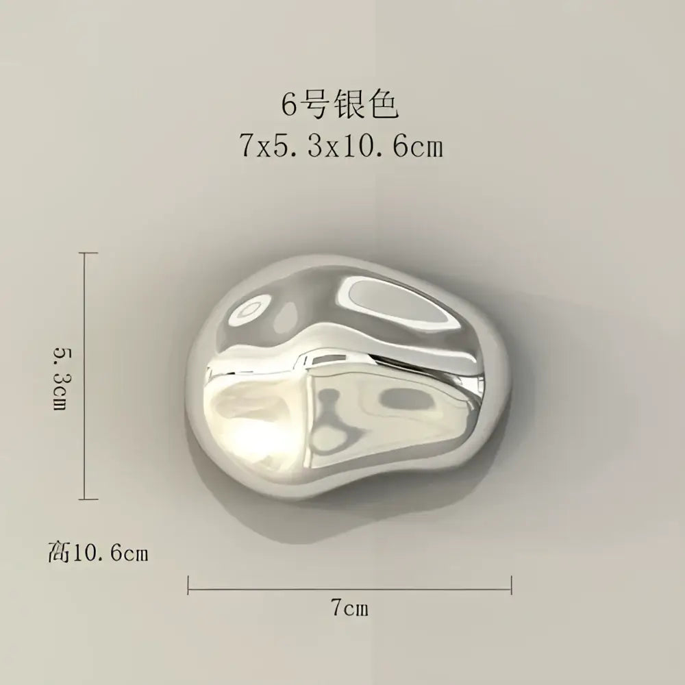 A sleek silver-toned metallic wall hanging ornament with a smooth teardrop shape for modern living room decor