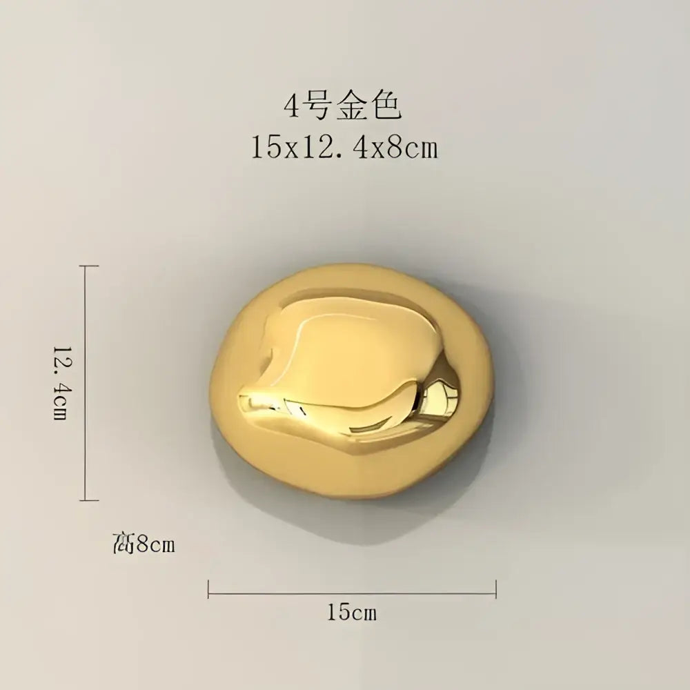 A smooth rounded gold metallic button with a raised design in modern gold and silver metallic wall hanging ornaments