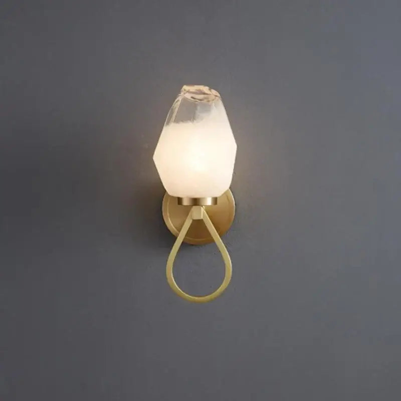 A modern wall sconce with frosted glass shade and brass base featured in decorbites adjustable brass kitchen decor