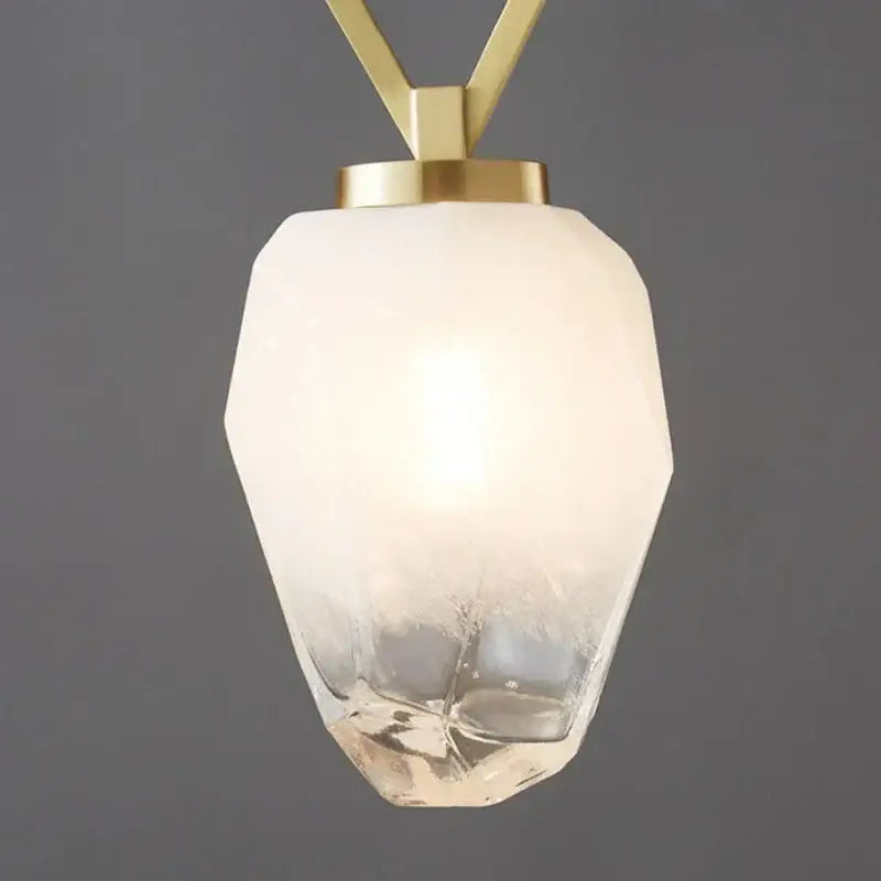 Modern pendant light with faceted frosted glass shade and gold-toned decorbites adjustable brass hardware