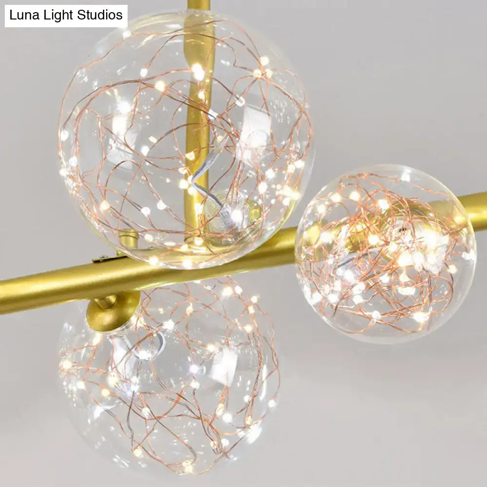 Modern gold spherical clear glass light fixture with three clear glass spheres and copper wire fairy lights for dining room