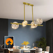 Modern gold spherical clear glass chandelier light fixture with five clear glass globe shades and warm led lights