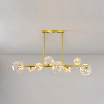 Modern gold spherical clear glass chandelier light fixture featuring gold-toned metal and clear glass globe bulbs