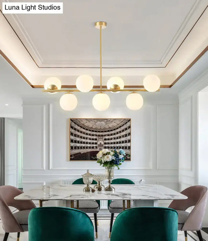 Modern gold-toned island ceiling light with six frosted glass globes pendant lighting for dining rooms