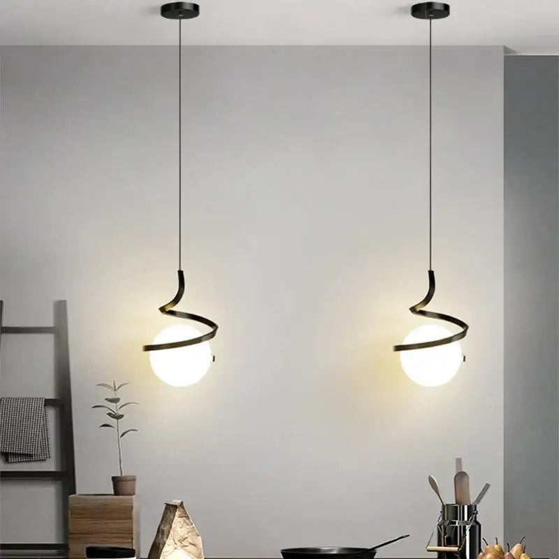 Two sleek black pendant lights with iron finish and frosted glass globes for modern dining room lighting