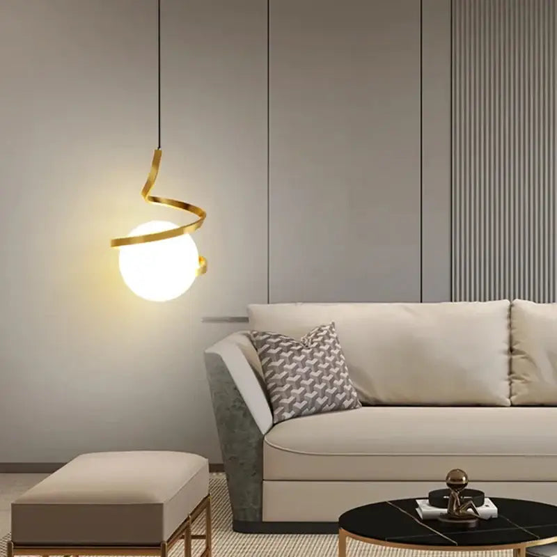 Modern gold spiral pendant light with glowing glass ball bulb and iron finish ideal for dining room lighting