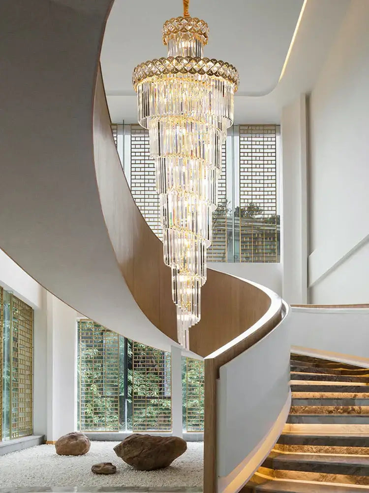 Modern gold stainless steel crystal chandelier with gold accents hanging above a spiral staircase decorbites gold stainless