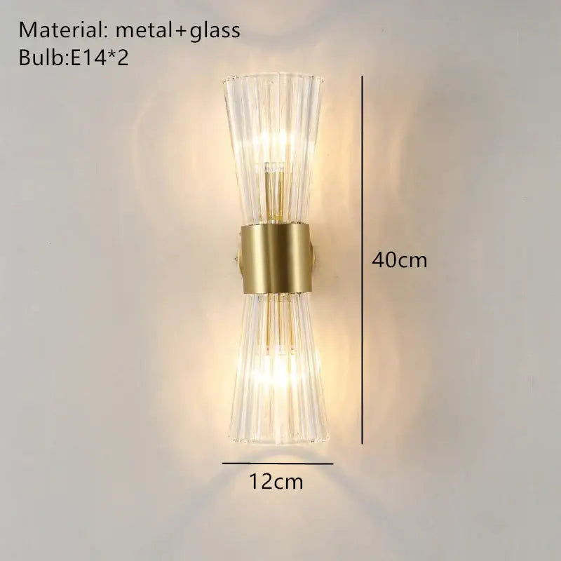 A modern gold stainless steel wall sconce with clear fluted glass panels for bedroom decorbites decor