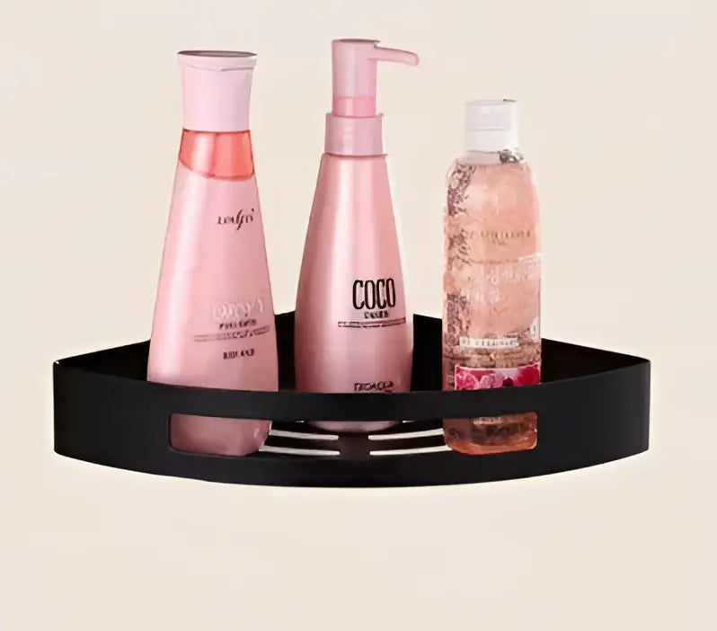 Black triangular decorbites gold stainless steel corner shelf holding three pink and clear hair care bottles