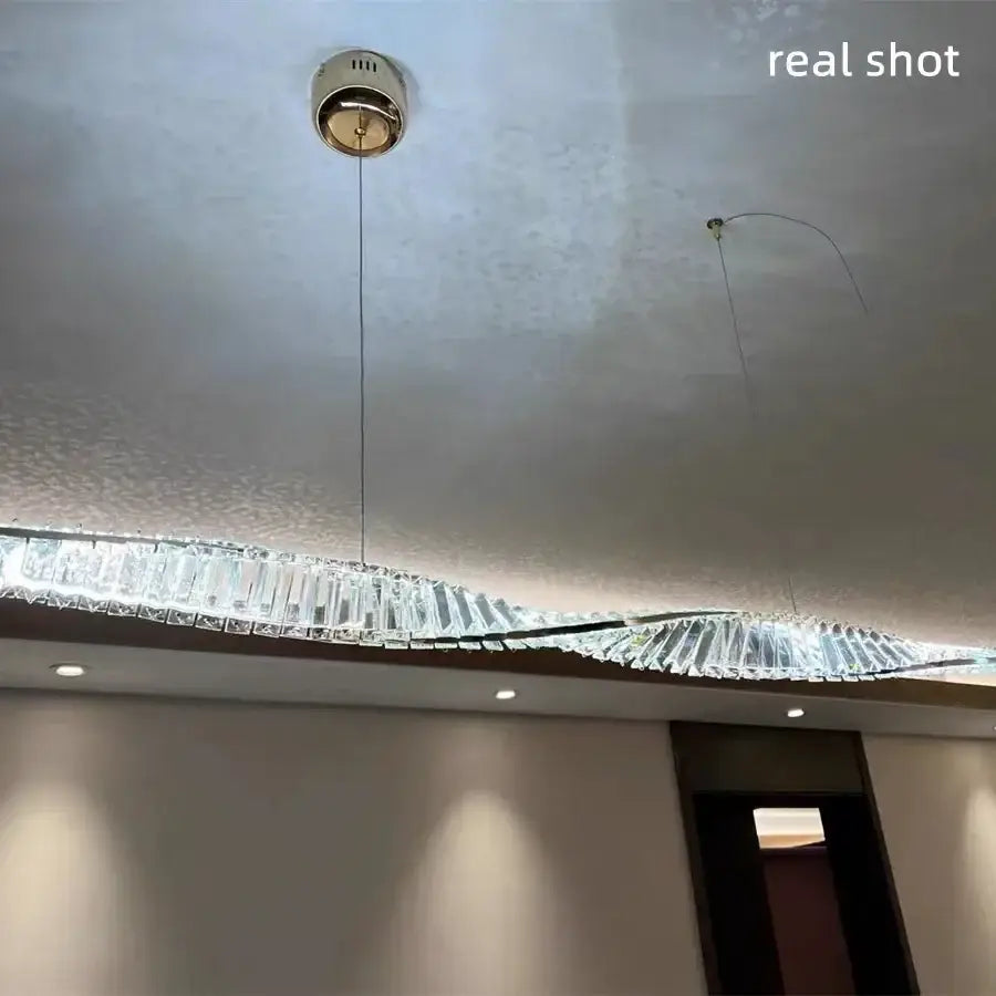 A modern gold steel led pendant light with wave-shaped clear crystal prisms for dining room decorbites gold steel chandelier