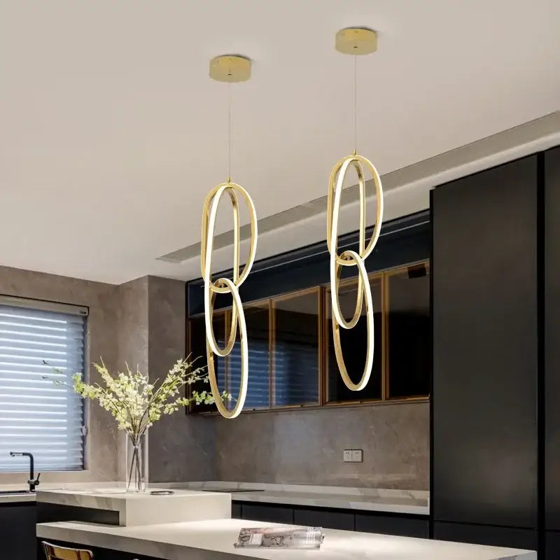 Modern gold steel pendant light with sleek interlocking rings for dining room by decorbites gold steel pendant