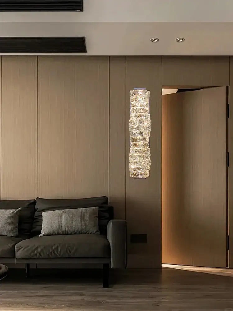 Modern gold textured glass wall sconce lamps with translucent crystal segments emitting warm light for bedroom decor