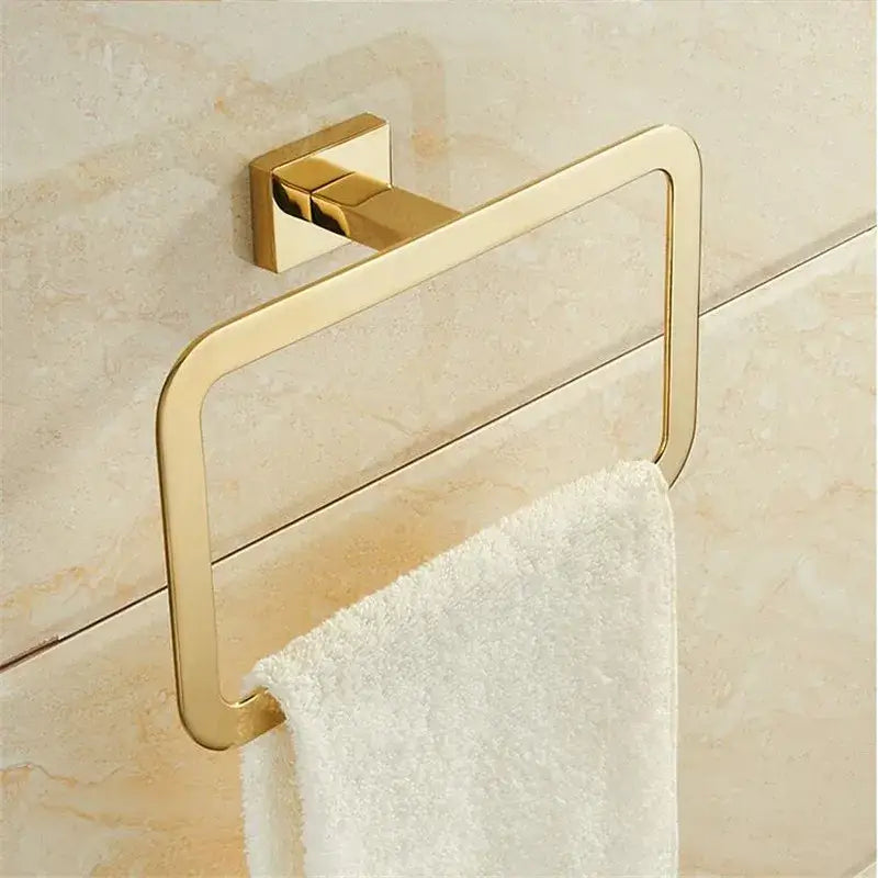 Modern gold towel ranger accessory rack with gold finish and sleek design mounted on a tiled bathroom wall