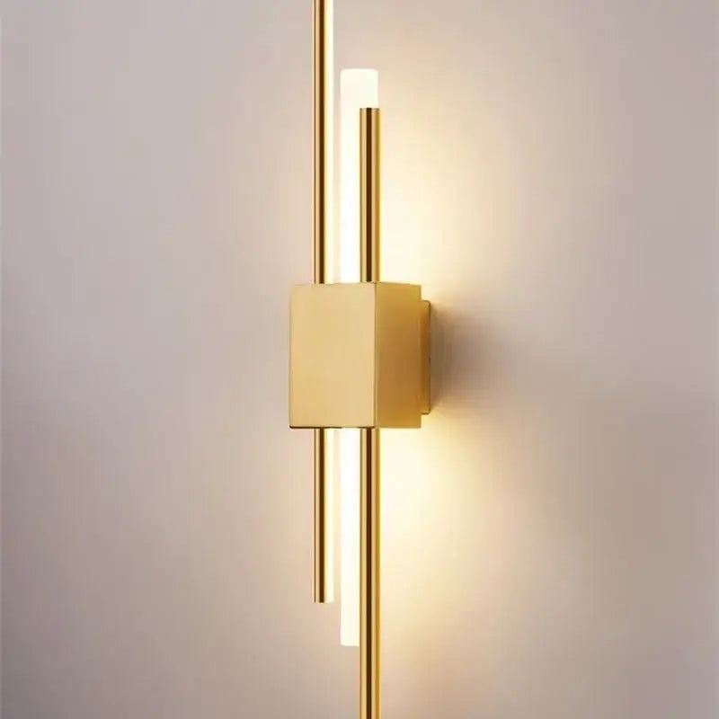 Modern gold tube wall sconce with sleek vertical rods and fabric diffuser emits warm ambient light for bedroom decorbites gold tube wall