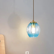 Modern gold tulip wall lamp with a translucent blue glass shade and brass-finished fixture for bedroom use