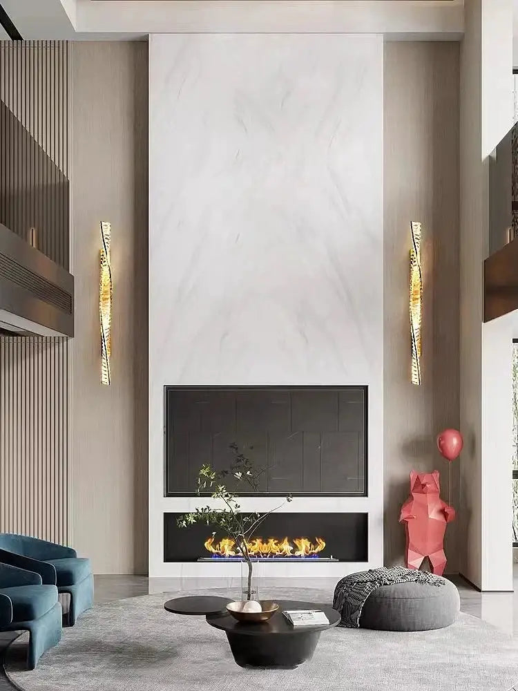 A sleek modern black fireplace with glowing flames set in white marble wall complements decorbites crystal wall sconce