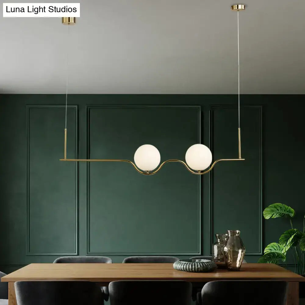 Modern gold two head pendant light with frosted glass shade and brass bulb base for dining room illumination