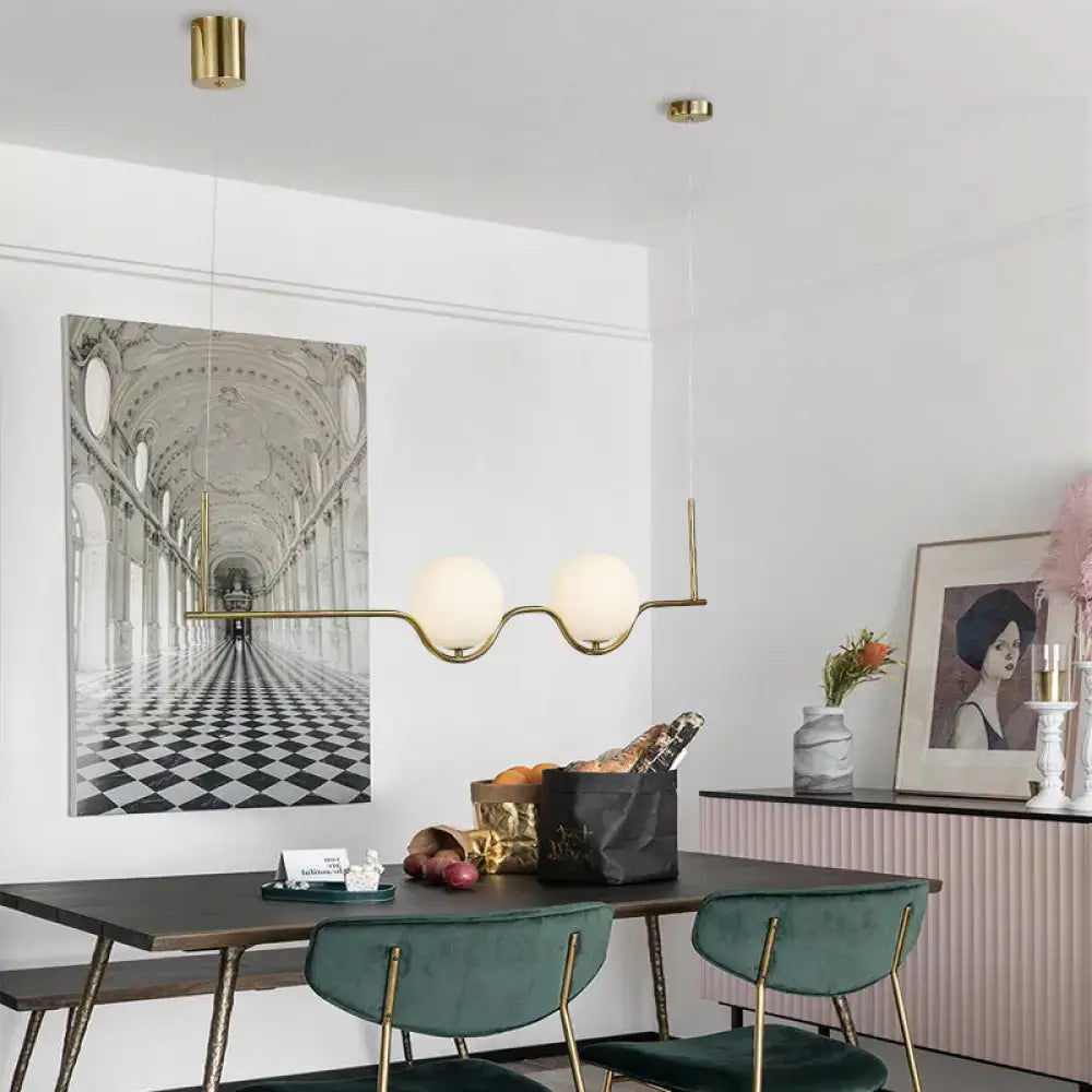 Modern gold two head pendant light with frosted glass shade and bulb base ideal for dining room lighting