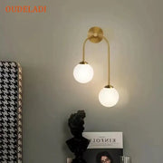 Modern gold wall lamp with two curved arms and frosted decorbites glass ball led shades for living room decor