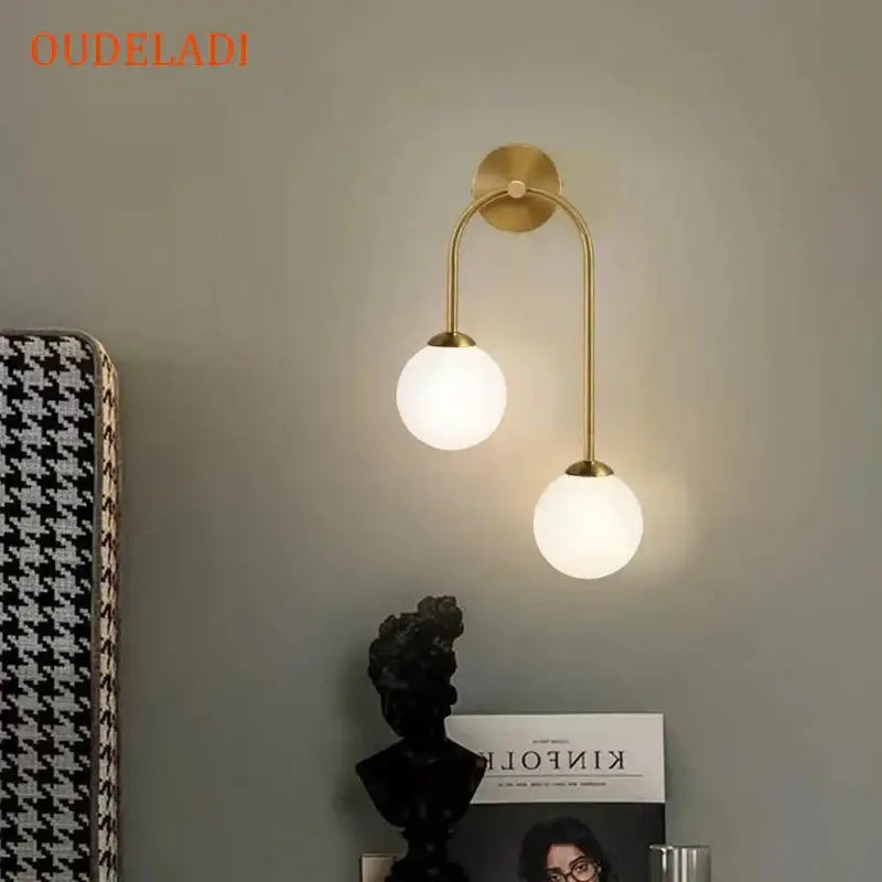 Modern gold wall lamp with two curved arms and frosted decorbites glass ball led shades for living room decor