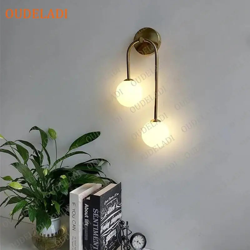 Modern gold two light wall lamp with brass finish and frosted glass ball led shades for elegant decorbites glass ball decor
