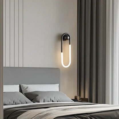 Modern black metal wall lights with curved u-shaped led emitting warm white light ideal for decorbites ellipse wall lighting