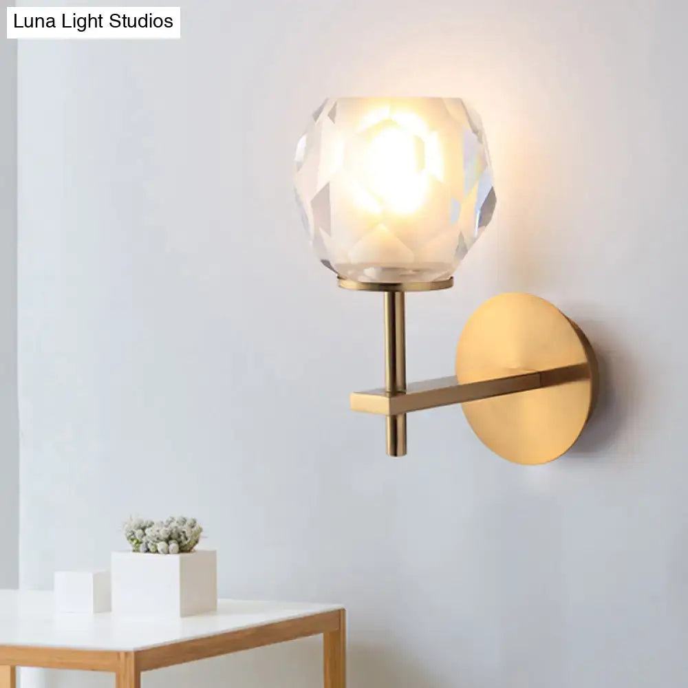Modern gold wall lamp with faceted globe shade and brushed brass arm as a wall mounted light for hallway