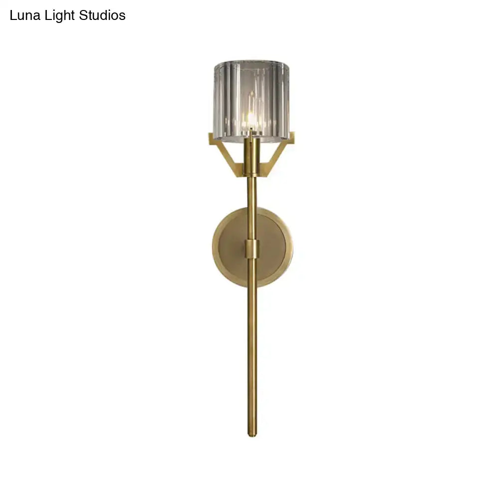 Modern gold wall light with brass finish and clear crystal block cylinder smoked glass shade for bedroom use