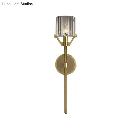 Modern gold wall light with brass finish and clear crystal block cylinder smoked glass shade for bedroom use