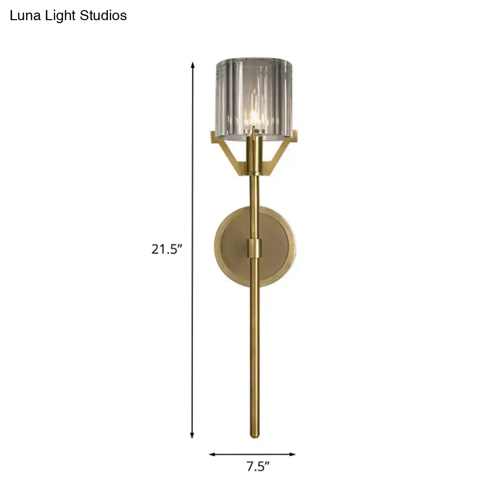 Modern gold wall light with a 21.5-inch tall brushed brass finish and clear crystal block cylinder shade for bedroom