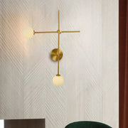 Modern gold wall mount lamp with closed glass globes and crossed wall mount design for living room lighting