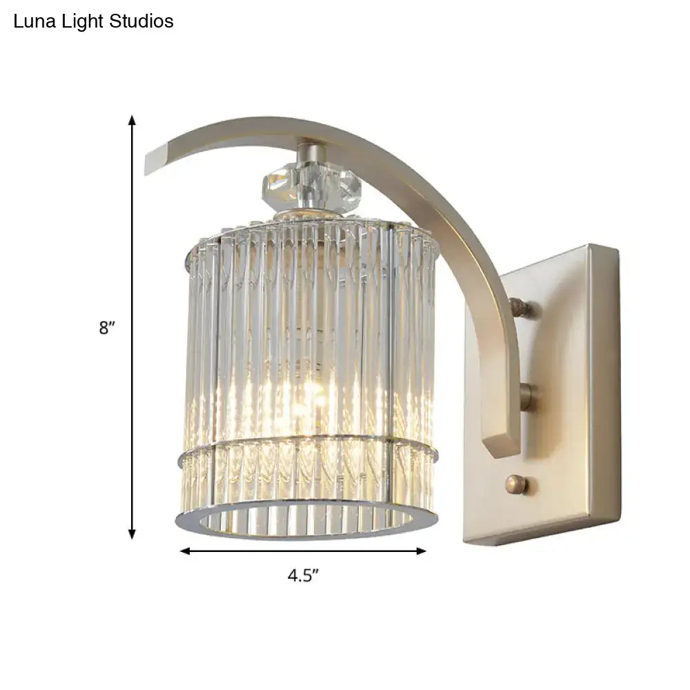 A sleek brushed nickel wall mounted lamp with a clear crystal ridged glass shade for bedroom lighting