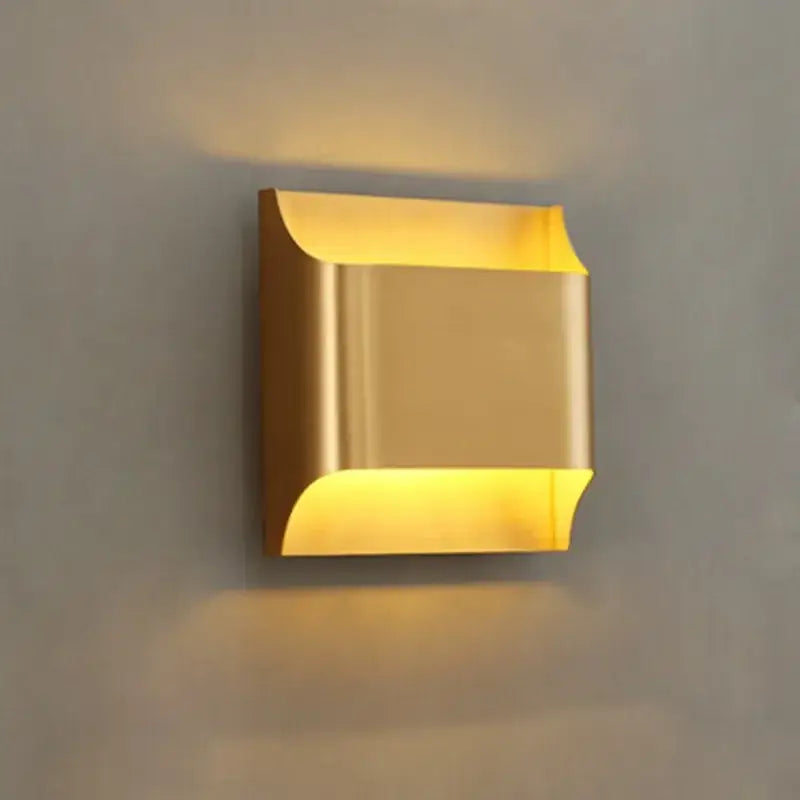 Modern gold wall sconce with sleek metallic finish and curved edges minimalist wall lamp by decorbites copper brass