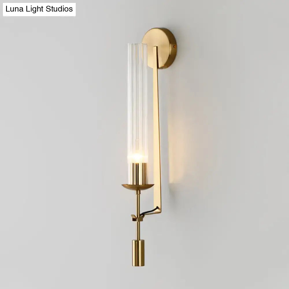 Modern gold wall sconce with clear glass shade featuring a gold-toned finish and sleek metallic accents for bathroom light
