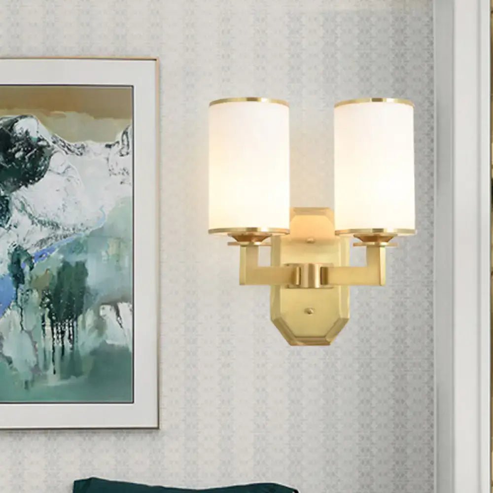 Modern gold wall sconce with opal glass cylindrical shades for bedroom lighting fixture