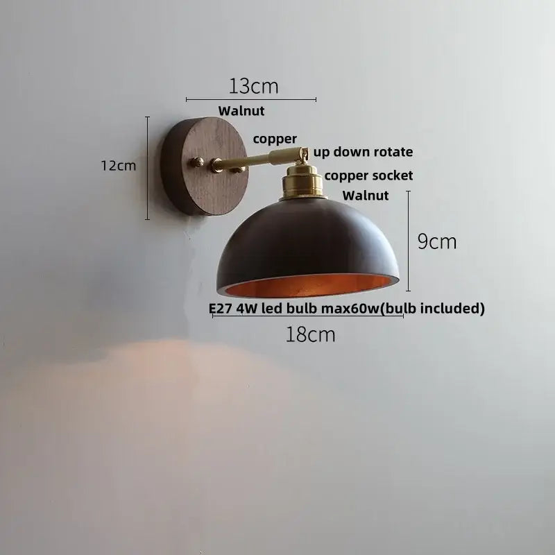 A sleek black dome wall sconce with walnut base copper accents and adjustable arm featuring pull chain switch for bedroom lighting