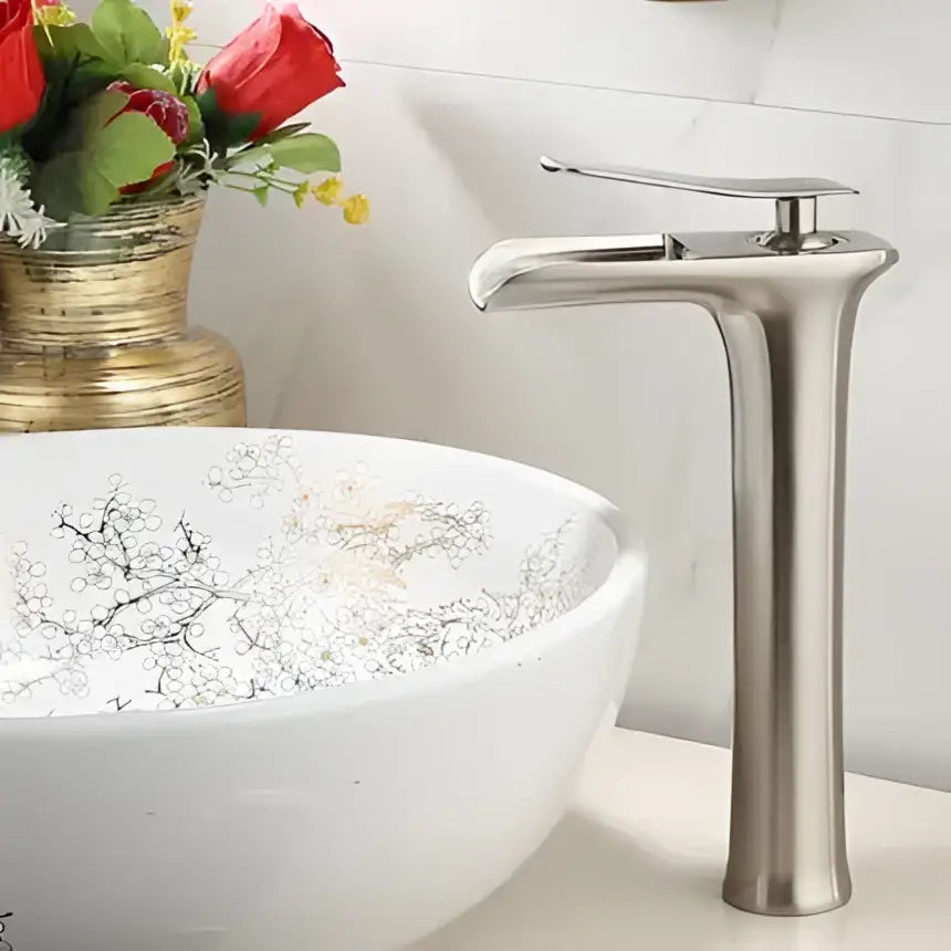 Modern brushed stainless steel basin faucet with sleek tall design complementing decorbites gold waterfall style