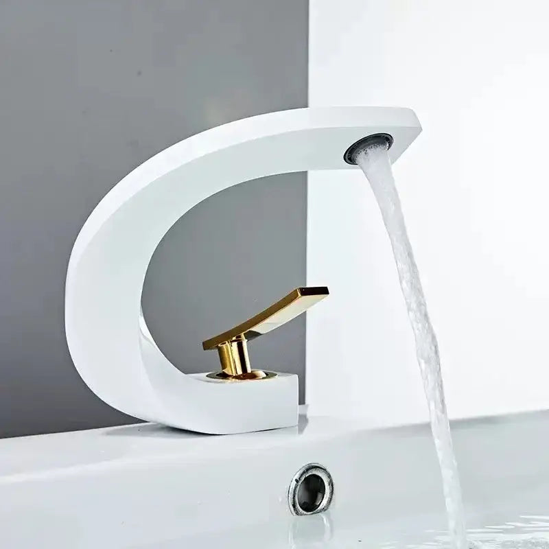 Modern white ceramic basin faucet with sleek curved design and gold-tone handle decorbites brass basin faucet