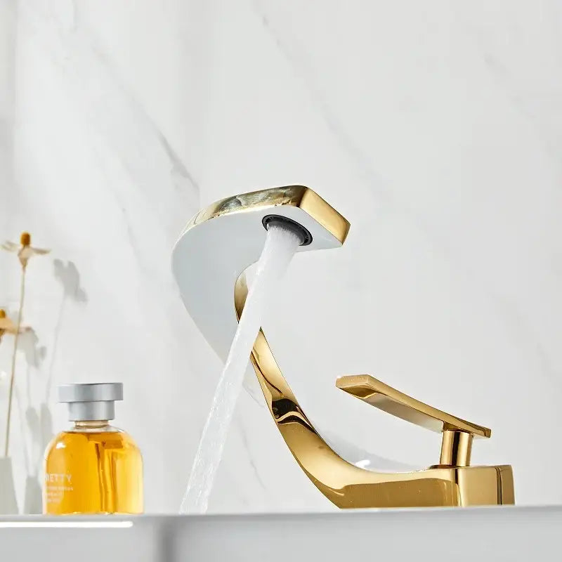 Modern gold waterfall mixer bathroom faucet with sleek curved design and flowing stream of water in gold finish