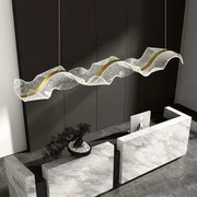 Modern pendant light with gold wave design featuring a translucent textured white acrylic body and gold accents