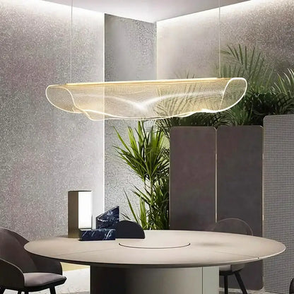 A modern gold wave mesh pendant light made of transparent material hanging above a dining room table decorbites dining room